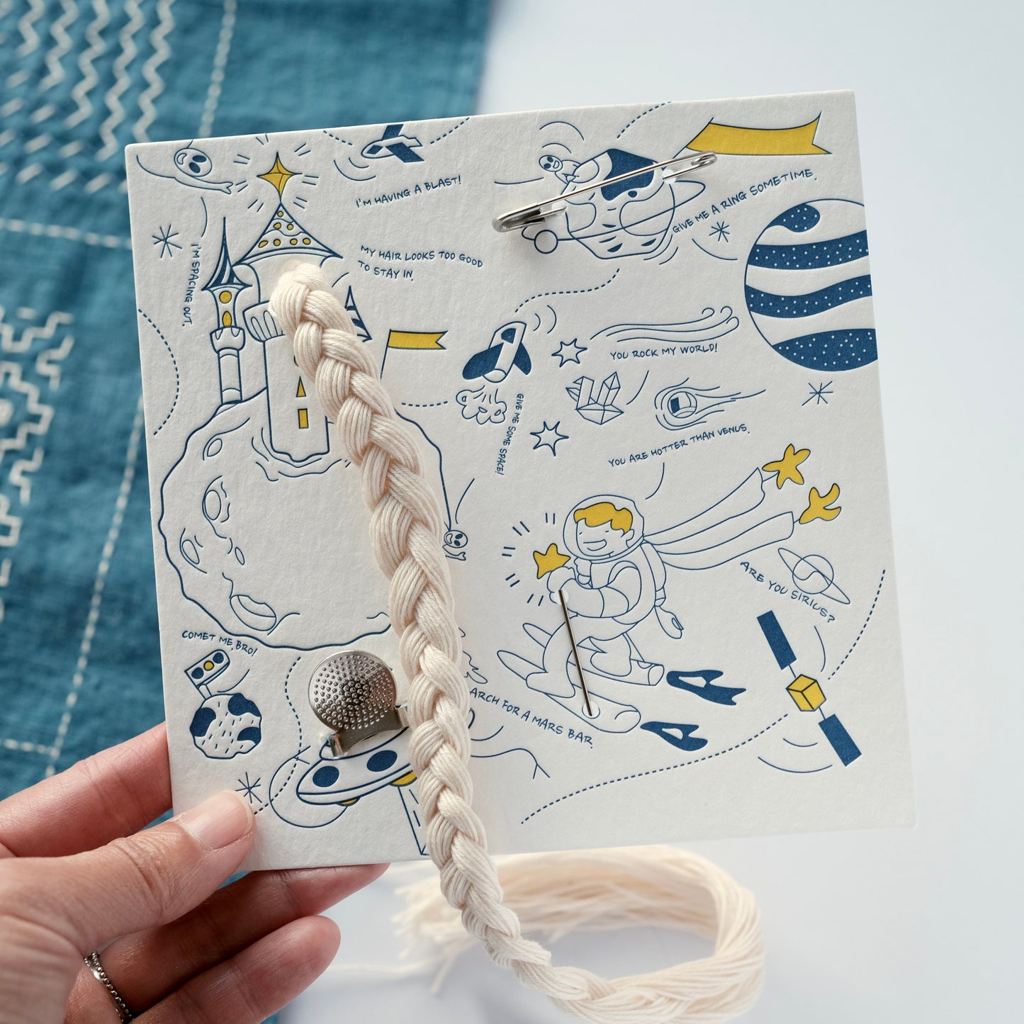 Close-up of Sashiko Starter Kit card held in hand, showing detailed design